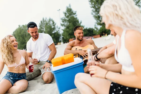 Группа Привлекательных Молодых Людей Наслаждающихся Пляжем Пьющих Играющих Гитаре — стоковое фото