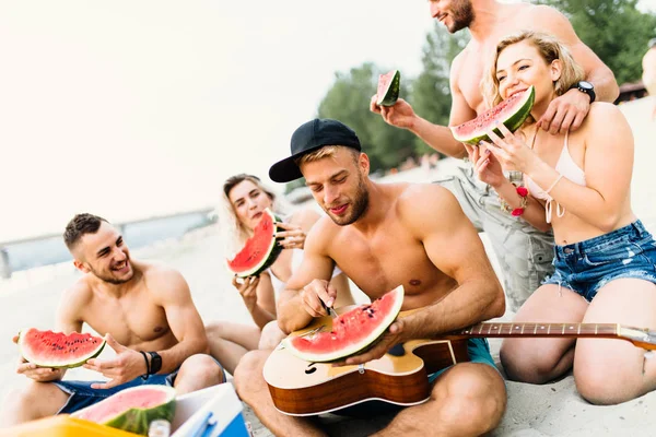 Группа Привлекательных Молодых Людей Наслаждающихся Пляжем Поедающих Арбуз — стоковое фото