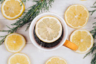 Bardak çay bardağı beyaz ahşap masa limon dilimleri ile kapatın. Yukarıdan fotoğrafı.