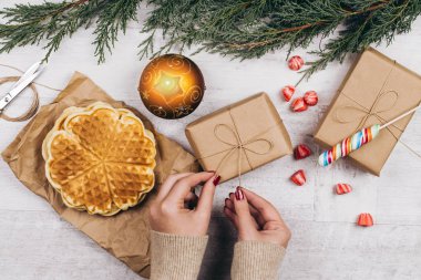 Eller genç kadın Noel hediyesi bir rustik Beyaz ahşap masa arka plan üzerinde kaydırma.