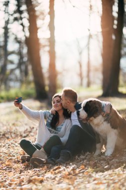 Açık havada çok güzel onların Saint Bernard köpek yavrusu ile birlikte zevk doğa genç çift. İnsanlar ve köpekler Tema.