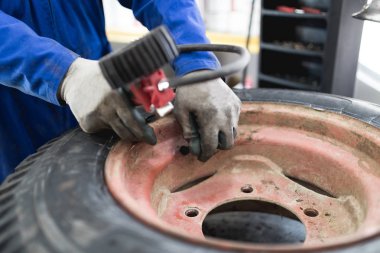 Lastik tamiri tamircisi. Gömlekler alt tire kullanılan.