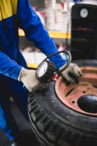 Mechanic repairing tire. Worker vulcanizing used tire.