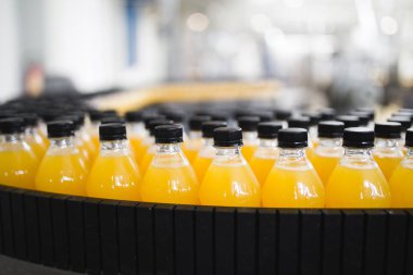 Endüstriyel fabrika kapalı ve makine. İşleme ve soda ve portakal suyu şişe şişeleme için robot fabrikası satır. Seçici odak. Kısa alan derinliği.