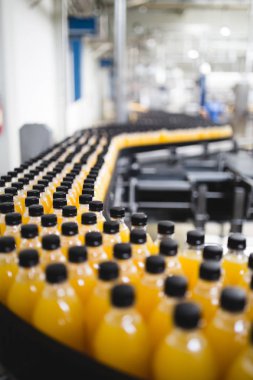 Endüstriyel fabrika kapalı ve makine. İşleme ve soda ve portakal suyu şişe şişeleme için robot fabrikası satır. Seçici odak. Kısa alan derinliği.