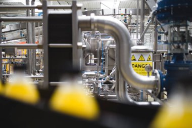 Endüstriyel fabrika kapalı ve makine. İşleme ve soda ve portakal suyu şişe şişeleme için robot fabrikası satır. Seçici odak. Kısa alan derinliği.