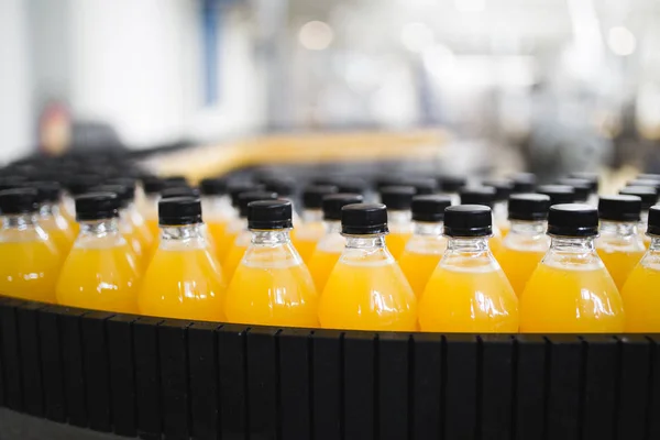 工場屋内 ロボット工場ラインの処理およびソーダ オレンジ ジュース ボトルの瓶詰め 選択と集中 短い被写し界深度 — ストック写真
