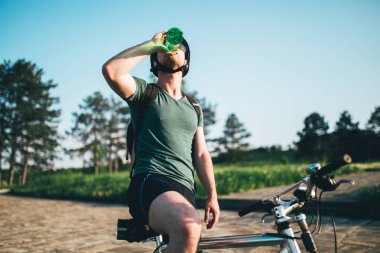 Dağ bisikletçinin günbatımı içme suyu