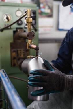 Metalurji ağır sanayi. Fabrika üretim ağır pelet soba ve kazanlar için. Çalışan eller kapatın. Son derece karanlık koşulları ve görünür gürültü.