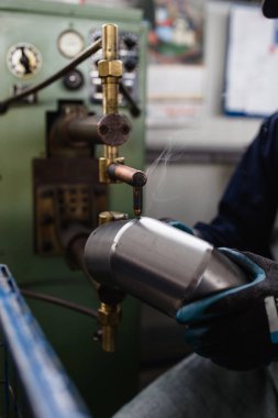 Metalurji ağır sanayi. Fabrika üretim ağır pelet soba ve kazanlar için. Çalışan eller kapatın. Son derece karanlık koşulları ve görünür gürültü.