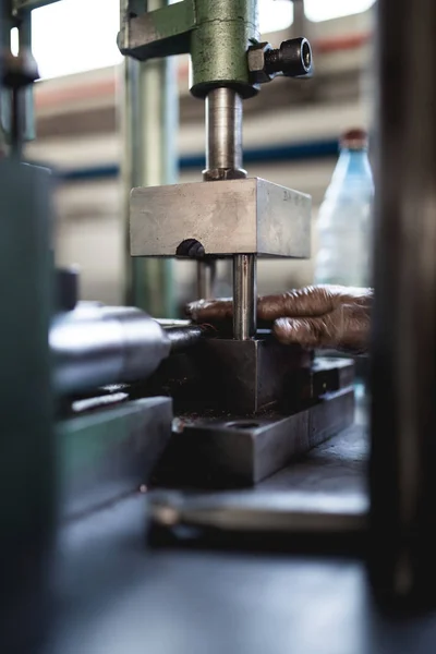 Metallurgy heavy industry. Factory for production of heavy pellet stoves and boilers. Worker hands close up. Extremely dark conditions and visible noise.