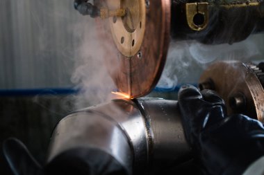 Metalurji Sanayi. Fabrika üretim ağır Pelet soba ve kazanlar için. İşçi Kaynakçı işini üzerine kapatın. Son derece karanlık koşulları ve görünür gürültü.