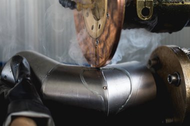 Metalurji Sanayi. Fabrika üretim ağır Pelet soba ve kazanlar için. İşçi Kaynakçı işini üzerine kapatın. Son derece karanlık koşulları ve görünür gürültü.