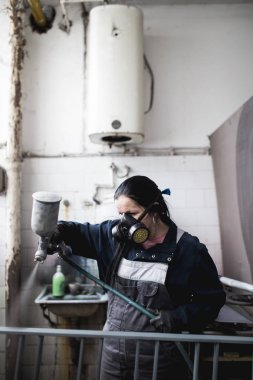 Güçlü ve değerli kadın zor iş yapıyor. Bazı metal ürünler boyama için endüstriyel sprey kompresör kullanıyor. 