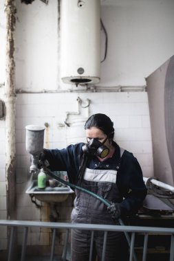 Güçlü ve değerli kadın zor iş yapıyor. Bazı metal ürünler boyama için endüstriyel sprey kompresör kullanıyor. 