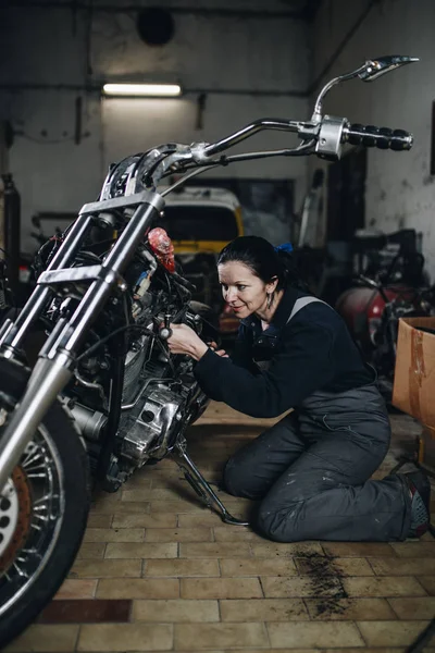 坚强而有价值的女人在汽车和摩托车修理厂做艰苦的工作 — 图库照片
