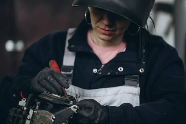 坚强而有价值的女人在汽车和摩托车修理厂做艰苦的工作 — 图库照片