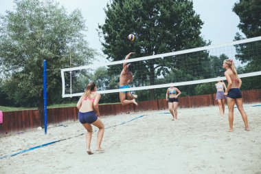 plaj voleybolu güzel güneşli günde oynayan genç arkadaşlar.
