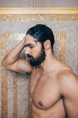 Genç yakışıklı bir sakal alarak duş portresi
