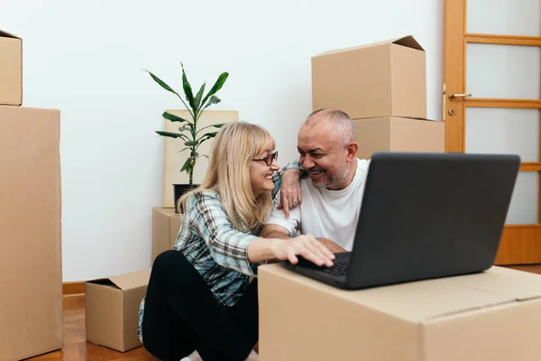 Pareja Mediana Edad Sentada Entre Cajas Nuevo Apartamento Usando Portátil — Foto de Stock