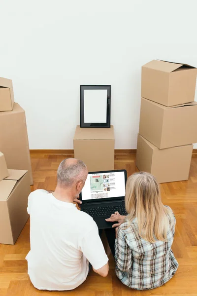 Pareja Mediana Edad Sentada Entre Cajas Nuevo Apartamento Usando Portátil — Foto de Stock