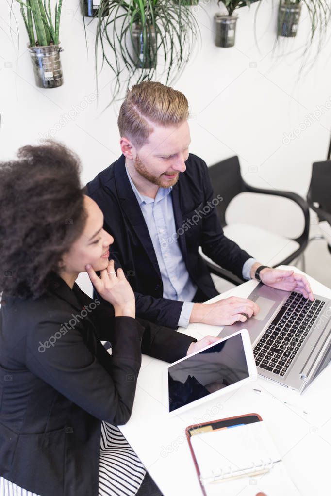 Multiracial business man and woman working together in modern office.