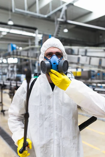 害虫制御ワーカー手を保持している噴霧器の噴霧殺虫剤生産や製造工場で — ストック写真