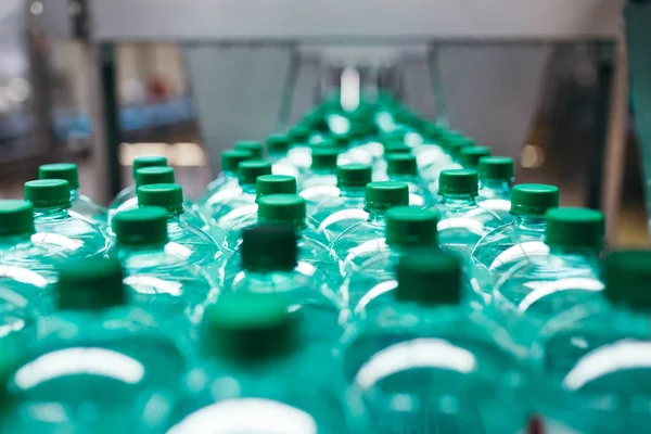 Industrial factory indoors and machinery. Robotic factory line for processing and bottling of pure spring water into canisters and bottles