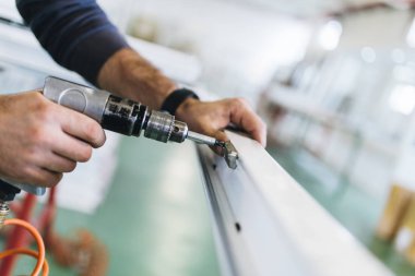 Alüminyum ve PVC profilleri kesen el işi işçisi. İmalat işleri. Seçici odaklanma. Alüminyum ve PVC pencere ve kapı üretim fabrikası.