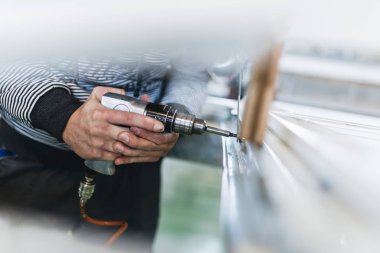 Alüminyum ve PVC profilleri kesen el işi işçisi. İmalat işleri. Seçici odaklanma. Alüminyum ve PVC pencere ve kapı üretim fabrikası.