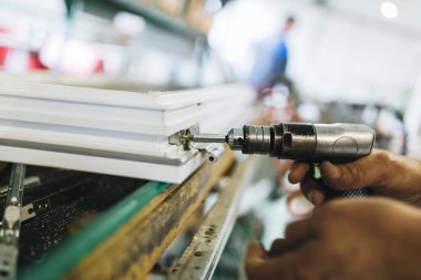 Alüminyum ve PVC profilleri kesen el işi işçisi. İmalat işleri. Seçici odaklanma. Alüminyum ve PVC pencere ve kapı üretim fabrikası.