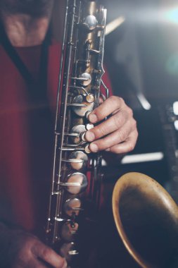 Saksafon oynamaya müzisyen atış kapatın. Düşük ışık ve seçici odak.
