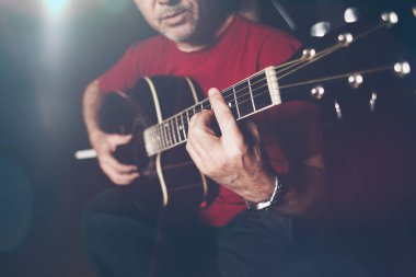 Gitar çalmak müzisyen atış kapatın. Düşük ışık ve seçici odak.