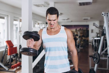 Fitness salonunda egzersiz genç çekici yetişkin bir adam. Kapalı eğitim spor.