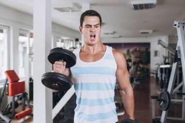 Fitness salonunda egzersiz genç çekici yetişkin bir adam. Kapalı eğitim spor.