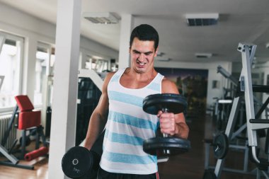 Fitness salonunda egzersiz genç çekici yetişkin bir adam. Kapalı eğitim spor.
