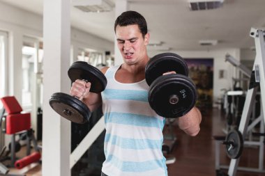 Fitness salonunda egzersiz genç çekici yetişkin bir adam. Kapalı eğitim spor.