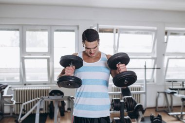 Fitness salonunda egzersiz genç çekici yetişkin bir adam. Kapalı eğitim spor.