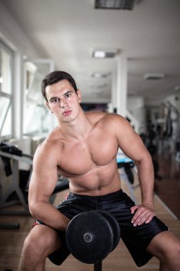 Fitness salonunda egzersiz genç çekici yetişkin bir adam. Kapalı eğitim spor.