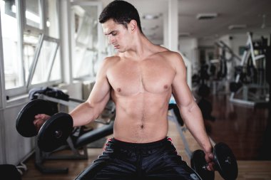 Fitness salonunda egzersiz genç çekici yetişkin bir adam. Kapalı eğitim spor.