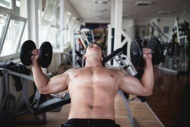 Fitness salonunda egzersiz genç çekici yetişkin bir adam. Kapalı eğitim spor.