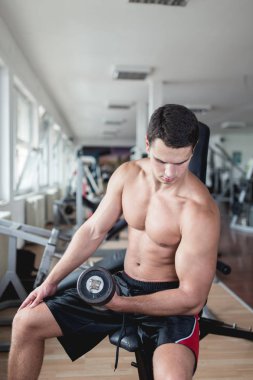 Egzersiz ve fitness spor salonunda ağırlık kaldırma işi genç çekici yetişkin bir adam. Kapalı eğitim spor.