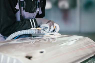 Araba - adam oto tamircisi otomobil parçaları boyama için hazırlanması ve parlatma zımparalama zımpara ile ayrıntılı. Elini tarih seçici odak.