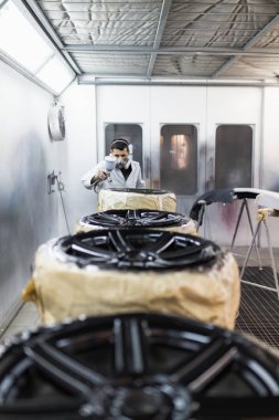 Koruyucu giysi ve araba parçaları sprey Kompresör kullanarak boyama maskesi olan adam. Seçici odak. 