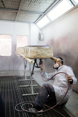 Koruyucu giysi ve araba parçaları sprey Kompresör kullanarak boyama maskesi olan adam. Seçici odak. 