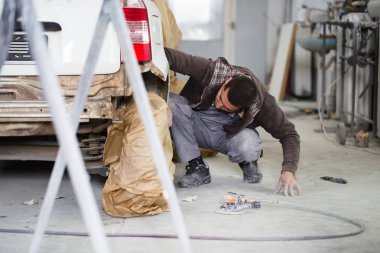 Araba - araba parçaları boyama için hazırlanması ve parlatma oto tamircisi yörünge Parlatıcı ile adam ayrıntılı. Seçici odak adamın el ve Perdah. 