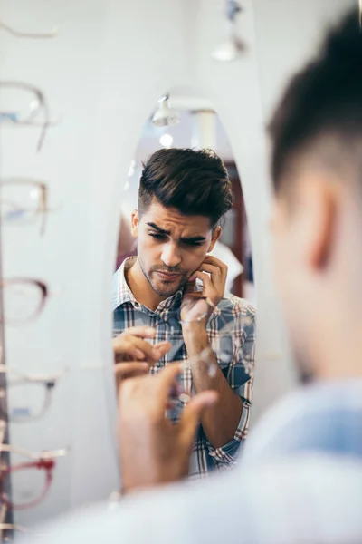 Stilig Ung Man Väljer Glasögonbåge Optisk Butik — Stockfoto