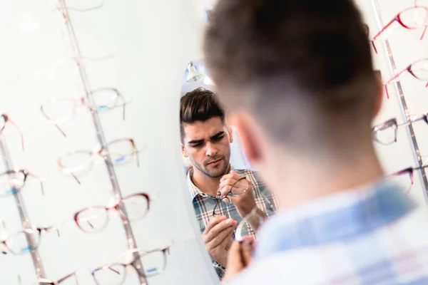 Bello Giovane Uomo Che Sceglie Occhiali Telaio Negozio Ottico — Foto Stock