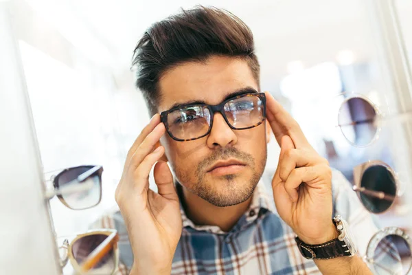 Stilig Ung Man Väljer Glasögonbåge Optisk Butik — Stockfoto