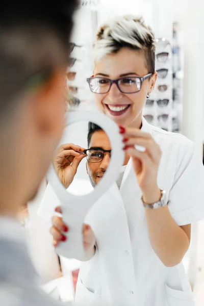 Jovem Optometrista Ajuda Cliente Escolher Óculos Certos — Fotografia de Stock